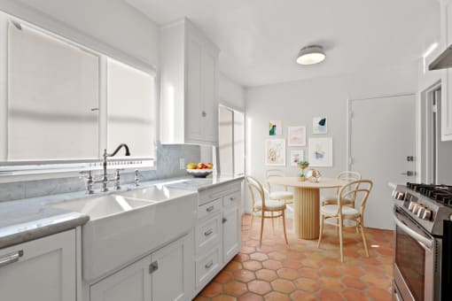 a kitchen with a sink and a table with chairs