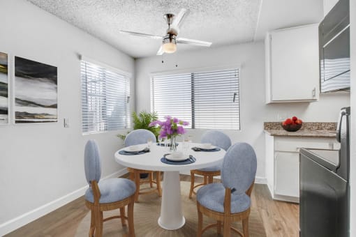 a dining room with a table and chairs and a ceiling fan