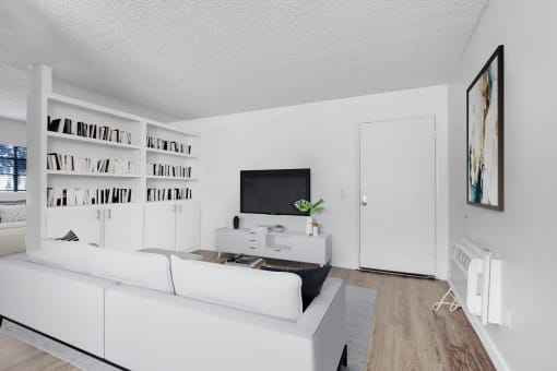 a living room with a white couch and a tv