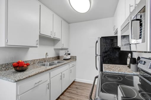 a kitchen with white cabinets and stainless steel appliances