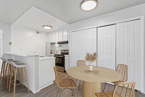 a dining room and kitchen with a table and chairs