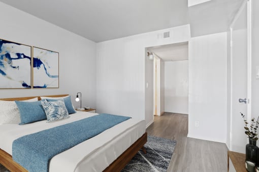 a bedroom with a white bed and a blue blanket