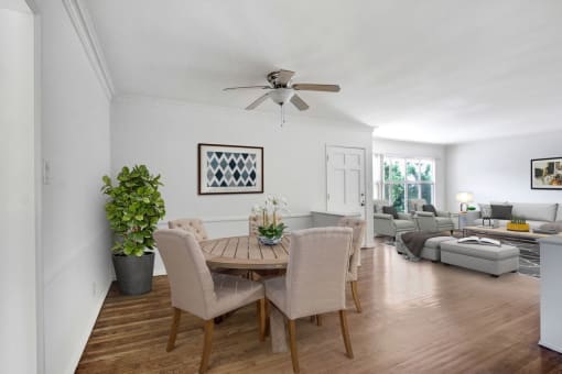 a dining room and living room with white walls and hardwood floors
