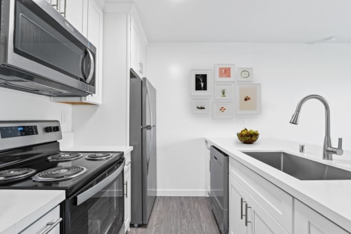 a kitchen with white cabinets and stainless steel appliances and a sink