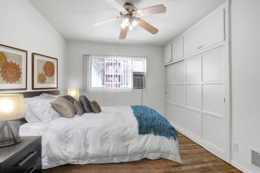 a bedroom with a large bed and a ceiling fan