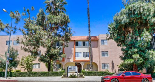 a red car parked in front of an apartment building