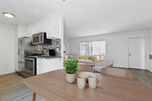 a living room with a wooden table and a kitchen