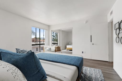 the master bedroom has a large bed and a large window