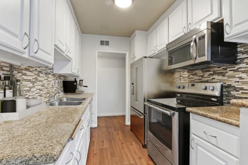 a kitchen with granite counter tops and stainless steel appliances