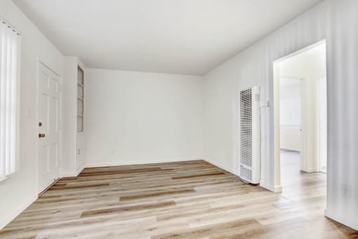 a bedroom with hardwood floors and white walls