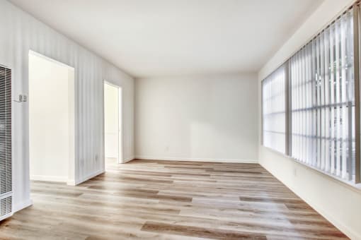 a bedroom with hardwood floors and white walls