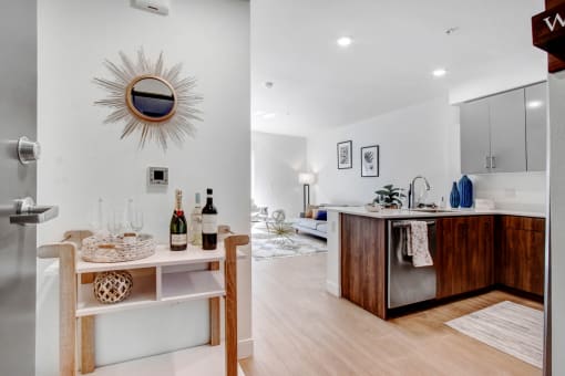a living room and a kitchen with a bar and a mirror
