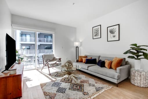 a living room with a couch and a rug and a large window