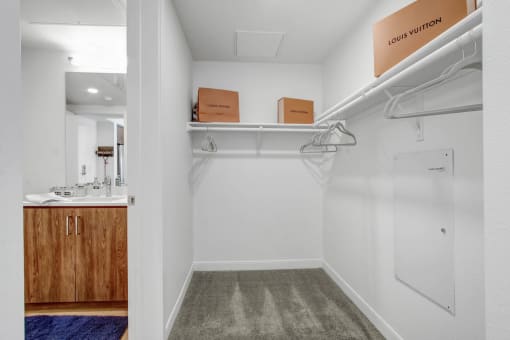 a white closet with boxes and hangers on a shelf