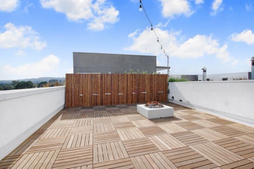 a roof terrace with wooden tiles and a wooden privacy fence