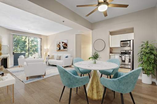 A modern dining room with a white table and blue chairs.