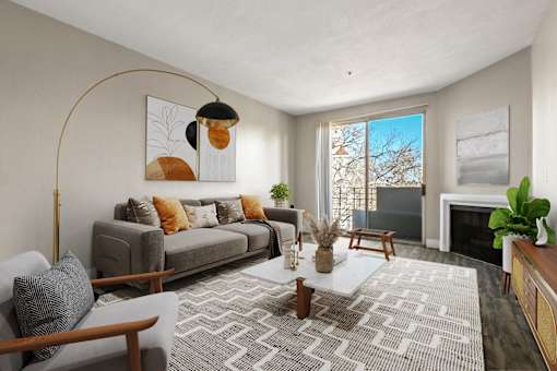 A living room with a grey sofa, a coffee table, and a fireplace.