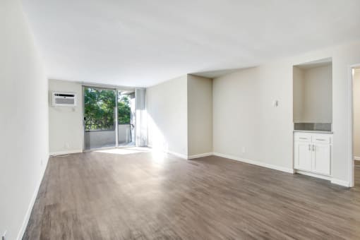an empty living room with white walls and a sliding glass door