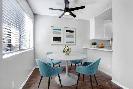 a dining room with a table and chairs and a ceiling fan