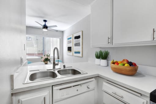 a white kitchen with a sink and a window