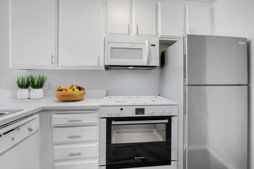 a white kitchen with an oven and a refrigerator