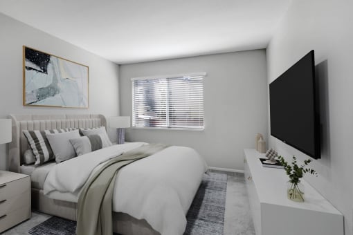 a white bedroom with a large bed and a tv