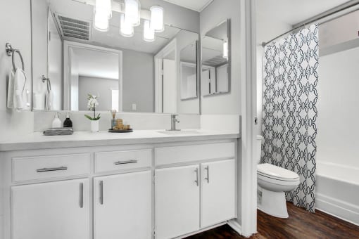 a white bathroom with a shower and a sink