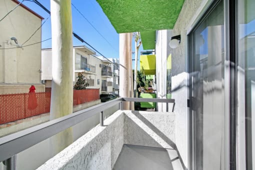 a balcony with a white railing and a green roof