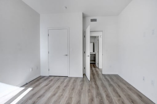 an empty living room with white walls and wood floors
