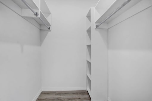 a room with white walls and a closet with shelves