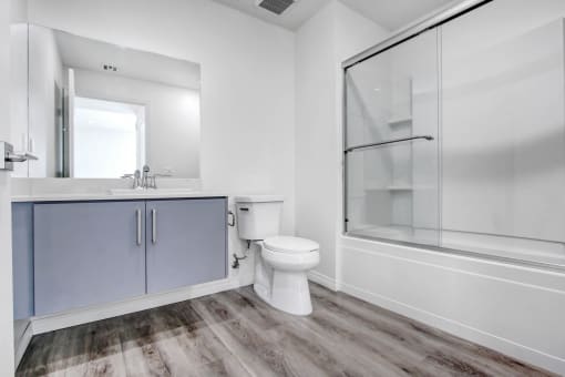 a white bathroom with a toilet and a shower