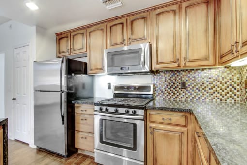 a kitchen with stainless steel appliances and wooden cabinets