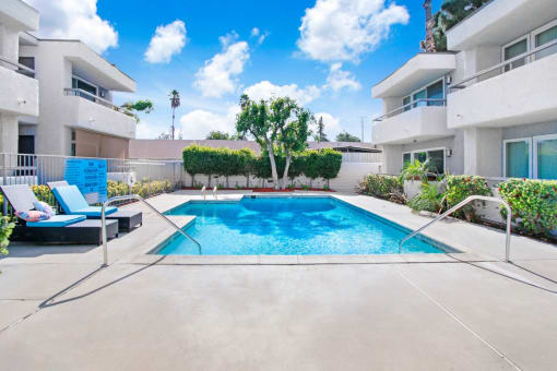 a swimming pool in the middle of a white apartment building