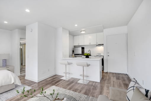 a white living room with a kitchen and a couch