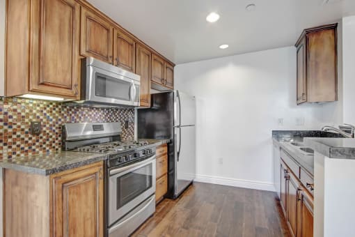 a kitchen with wooden cabinets and stainless steel appliances