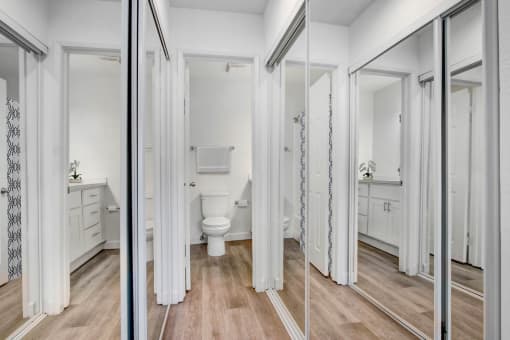 a white bathroom with a toilet and a mirror