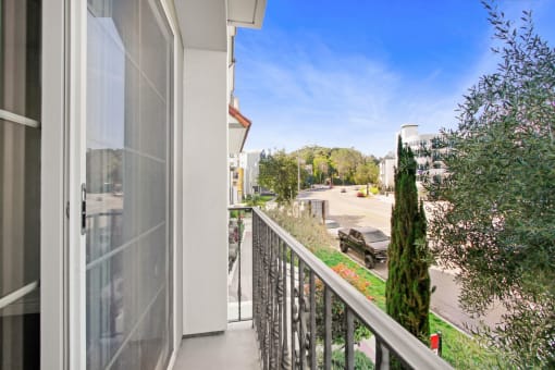 a balcony with a view of a street and a building with a glass door