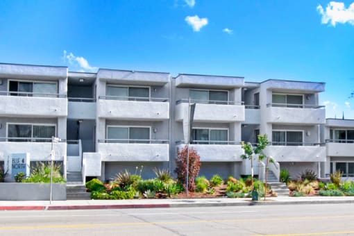 a white apartment building with a street in front of it