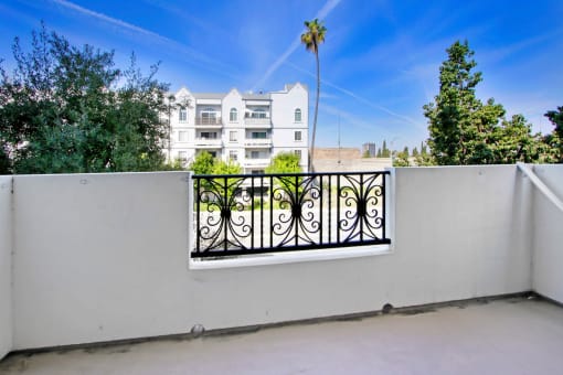 a balcony with a fence and a building in the background