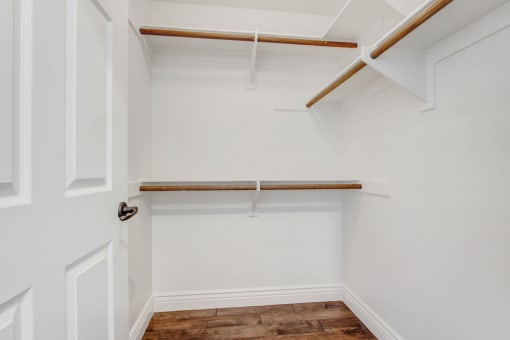 a walk in closet with white walls and a white closet with a white door