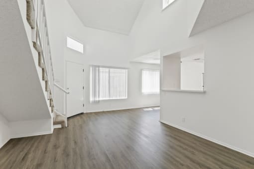 an empty living room with white walls and wood floors