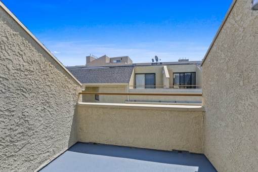 a balcony with a view of a building and a blue sky