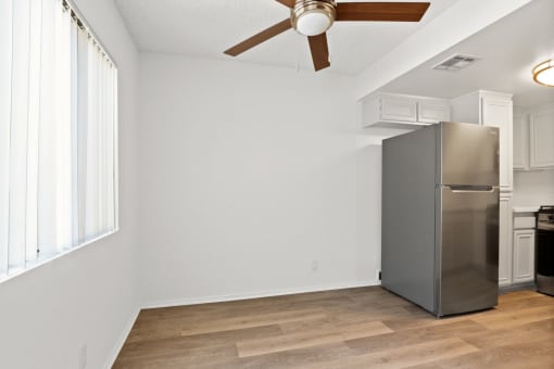a kitchen with a stainless steel refrigerator and a ceiling fan