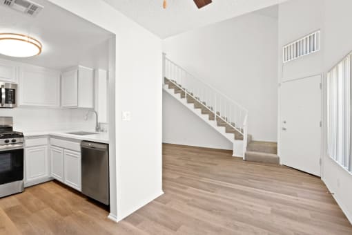 an open kitchen and living room with a staircase in a home