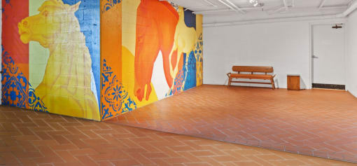 an empty room with a mural and a bench