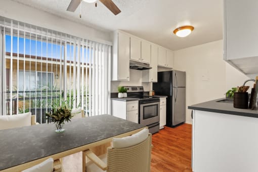 a kitchen and dining area with a large window and stainless steel appliances