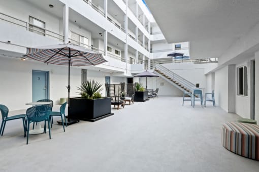 a large room with tables and chairs and umbrellas in an office building