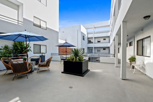 an outdoor patio with tables and chairs and umbrellas at a building