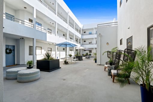 a large courtyard with seating and umbrellas in a hotel