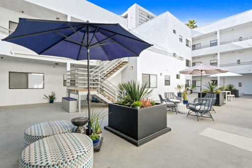 a patio with tables and umbrellas and chairs and a staircase